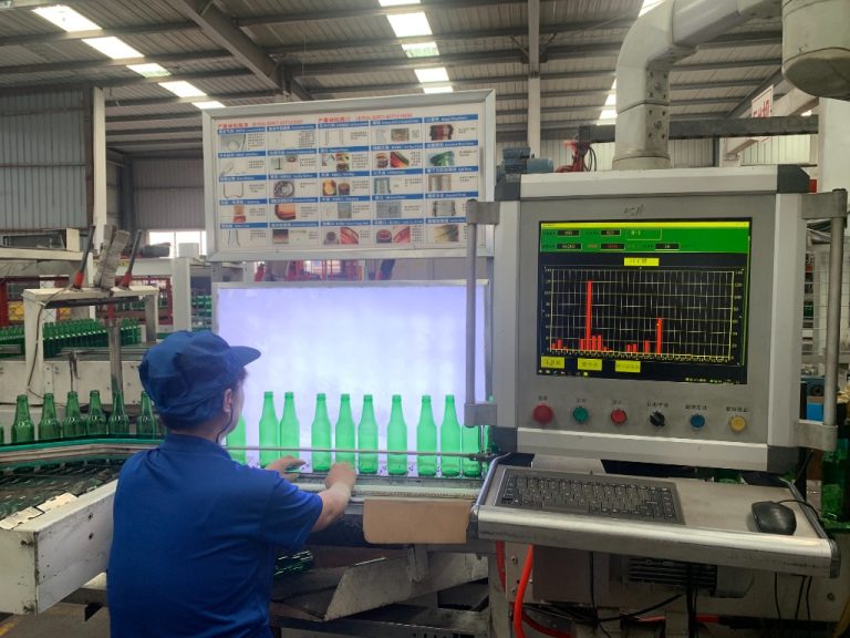 Jinpeng Glass quality control technician monitoring green beer bottles on automated optical and manual light inspection line