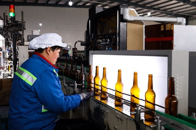 glass bottle inspection process - manual light inspection at the cold end